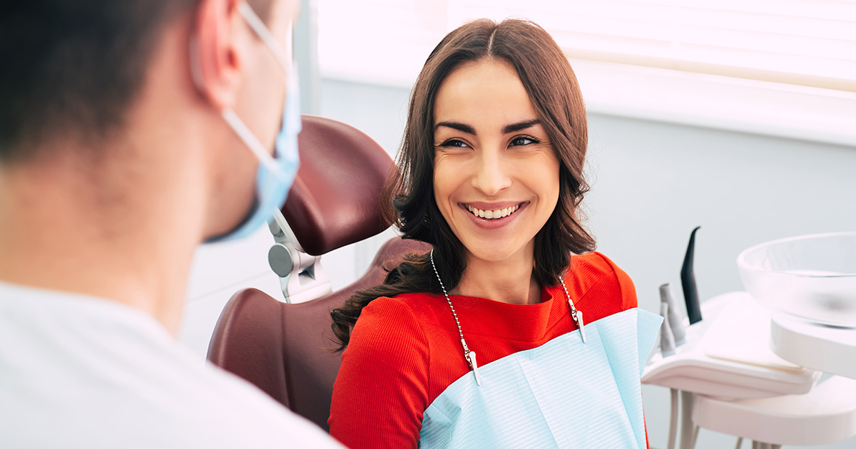 Woman in dental chair smiling at the doctor