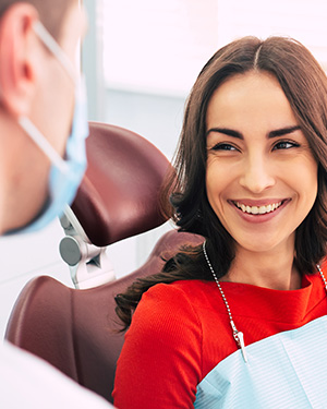 Woman in dental chair smiling at the doctor