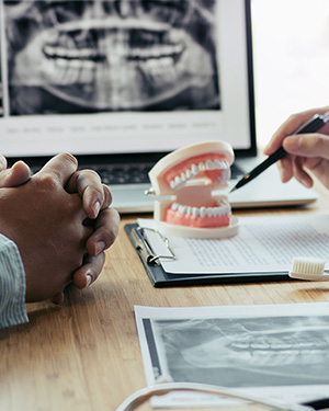 Closeup of hands reviewing a set of dental implants on a desk